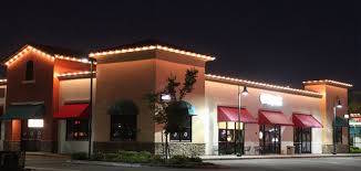 Commercial Christmas lighting in Denver CO - building entrance with festive holiday lights and wreaths